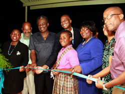 Eight- year-old Aaliyah Farmer of the Golden Lane Gov’t Primary School assist THA Chief Secretary Orville London and Secretary of Health and Social Services Claudia Groome-Duke in cutting the ribbon to officially open the Golden Lane health facility on Tuesday night. Photo THA Info Dept. grd-img