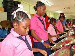 Students of Montgomery Primary School enjoy playing on the pan instruments received from DEYAS at their school compound on Monday (November 11, 2013).